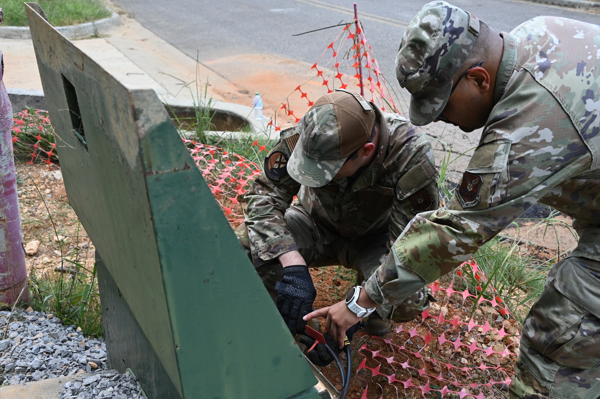 U.S. Air Force Tech. Sgt. Christopher Harden and Staff Sgt. Abishesh Phuyal, airmen with the 117th Communications Squadron, identify cabling for the base wi-fi system.