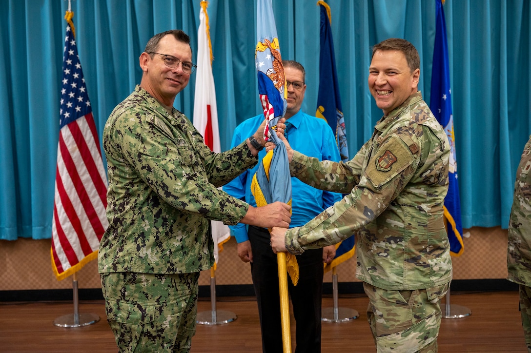 Two men holding a flag.