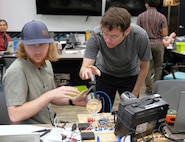 DAHLGREN, Va. – William Urbanic (left), a mechanical engineer, and Trevor Acosta, an optics/photonics engineer, build a low-budget coffee can radar during a Workforce Development Innovation Challenge at Naval Surface Warfare Center Dahlgren Division. (Tierney Kunstmann/NSWCDD Photo)