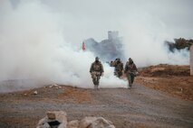 U.S. Marines with Headquarters Battalion, 1st Marine Division, hike as a battalion through o-chlorobenzlidene malonoitrile gas at Marine Corps Base Camp Pendleton, California, July 18, 2025. The purpose of the hike was to test physical readiness and improve combat conditioning. (U.S. Marine Corps photo by Cpl. Juan Torres)