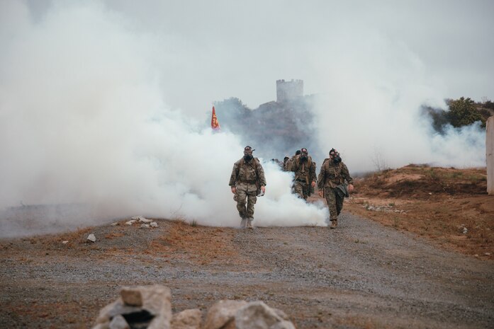 U.S. Marines with Headquarters Battalion, 1st Marine Division, hike as a battalion through o-chlorobenzlidene malonoitrile gas at Marine Corps Base Camp Pendleton, California, July 18, 2025. The purpose of the hike was to test physical readiness and improve combat conditioning. (U.S. Marine Corps photo by Cpl. Juan Torres)