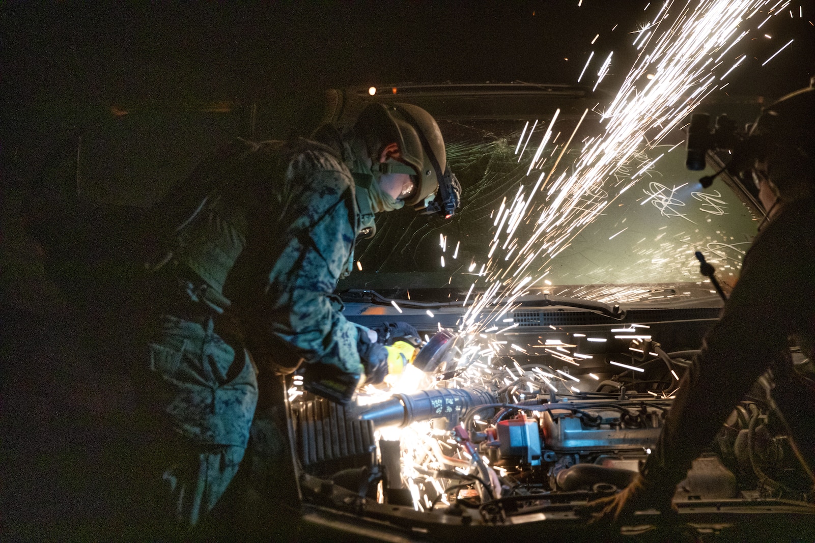 U.S. Marines Corps Pfc. Ciraje Cishahayo, an expeditionary firefighting and rescue specialist with 1st Battalion, 5th Marine Regiment, 1st Marine Division, saws into a vehicle during a tactical recovery of aircraft and personnel course at Marine Corps Base Camp Pendleton, California, July 10, 2025. The TRAP course is designed to develop the capabilities of Marines to recover aircraft, personnel, and equipment in austere environments.  (U.S. Marine Corps photo by Lance Cpl. Zackery Dear)