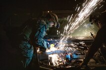 U.S. Marines Corps Pfc. Ciraje Cishahayo, an expeditionary firefighting and rescue specialist with 1st Battalion, 5th Marine Regiment, 1st Marine Division, saws into a vehicle during a tactical recovery of aircraft and personnel course at Marine Corps Base Camp Pendleton, California, July 10, 2025. The TRAP course is designed to develop the capabilities of Marines to recover aircraft, personnel, and equipment in austere environments.  (U.S. Marine Corps photo by Lance Cpl. Zackery Dear)