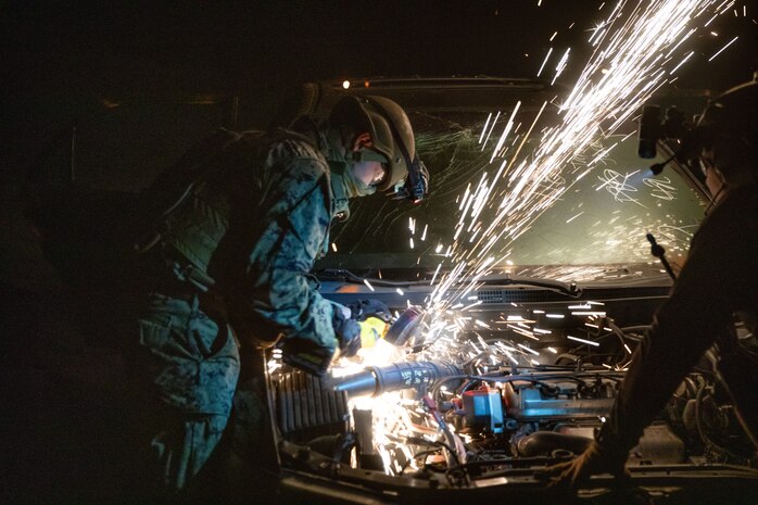 U.S. Marines Corps Pfc. Ciraje Cishahayo, an expeditionary firefighting and rescue specialist with 1st Battalion, 5th Marine Regiment, 1st Marine Division, saws into a vehicle during a tactical recovery of aircraft and personnel course at Marine Corps Base Camp Pendleton, California, July 10, 2025. The TRAP course is designed to develop the capabilities of Marines to recover aircraft, personnel, and equipment in austere environments.  (U.S. Marine Corps photo by Lance Cpl. Zackery Dear)
