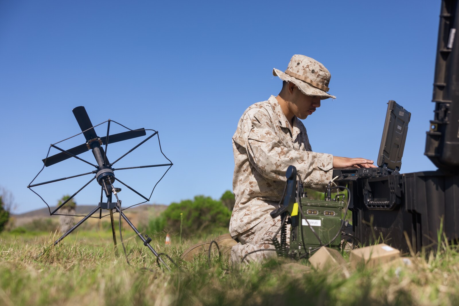 U.S. Marine Corps Cpl. Victorino Betancourtfarias, a transmissions systems operator with Headquarters Battalion, 1st Marine Division, utilizes a radio during the annual division communications competition at Marine Corps Base Camp Pendleton, California, June 17, 2025. The competition brought together communications Marines from across the division to evaluate their technical expertise and application of communications gear and principles. Betancourtfarias is a native of California. (U.S. Marine Corps photo by Lance Cpl. Earik Barton)