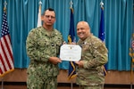 Two men display an award.