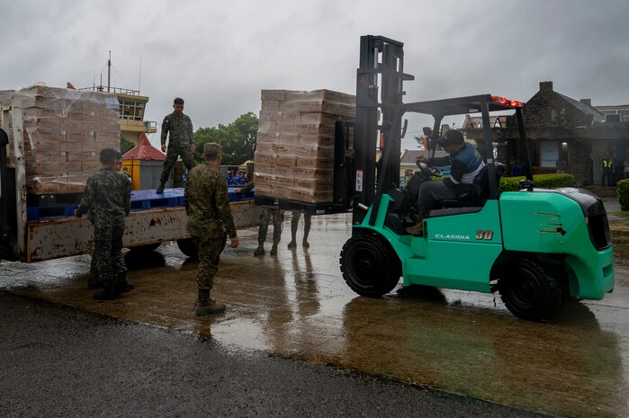 Philippine Marines secure Department of Social Welfare and Development family food packs delivered by CV-22 Ospreys.