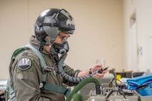 U.S. Air Force Capt. Ryan Gorski, 9th Bomb Squadron pilot, puts on flight equipment in preparation for a mission in support of Red Flag-Nellis 25-3 at Dyess Air Force Base, Texas, July 25, 2025. Red Flag 25-3 gave Dyess aviators the opportunity to fly both as “Blue Air” and “Red Air,” alternating between friendly strike roles and simulated adversary missions. (U.S. Air Force photo by Airman Caleb Schellenberg)