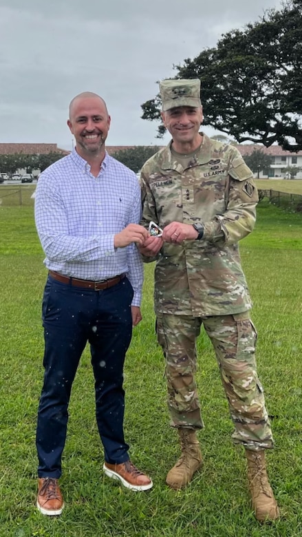 Jeremy McCranie, previous Honolulu District Safety & Occupational Health Manager, presents Lt. Gen. Scott A. Spellmon, 55th Chief of Engineers of the U.S. Army Corps of Engineers, with a Quality Triangle U.S. Army Corps of Engineers Safety and Occupational Health Management System (CE-SOHMS) coin to thank him for his advocacy for safety Feb. 27, 2023. Spellmon had just given McCranie a command coin to recognize his contributions to the USACE safety program. McCranie now serves as the chief of Safety & Occupational Health at the U.S. Army Engineering & Support Center Huntsville.