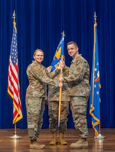 Lt. Col. Nicole Fink presents the guidon to Maj. Daniel Wright