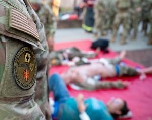 A uniform patch that reads "OPERATION HEALTHY ELLWOOD INNOVATIVE READINESS TRAINING" rests on a uniform below an American flag patch.