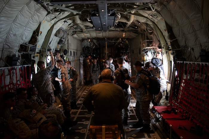 Civil Air Patrol cadets roam around the back of a C-130J during a flight.