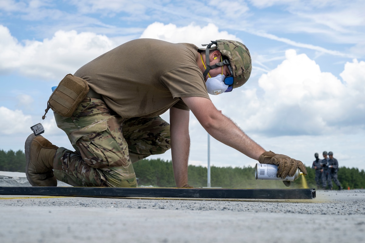 A U.S. Air Force Airman assigned to the 35th Civil Engineer Squadron spray paints markers around a crater during a rapid airfield damage repair exercise as a part of exercise Resolute Force Pacific  2025 at Draughon Range near Misawa Air Base, Japan, July 29, 2025.