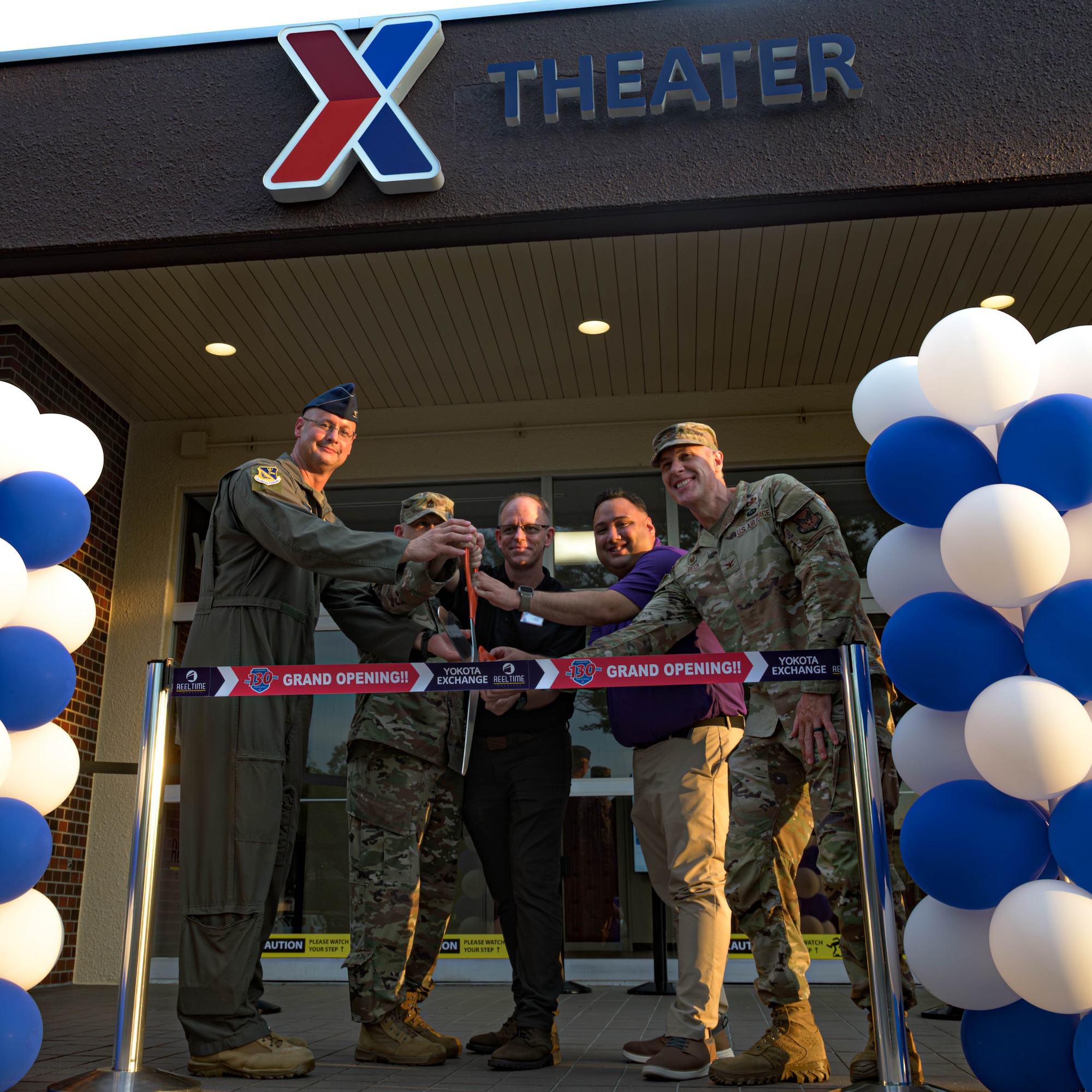 Members of Team Yokota participate in a ribbon cutting for the grand reopening of the base theater at Yokota Air Base, Japan, July 25, 2025. The theater offers a space that enhances morale, fosters connection, and contributes to the quality of life for Airmen, families, and the broader base community