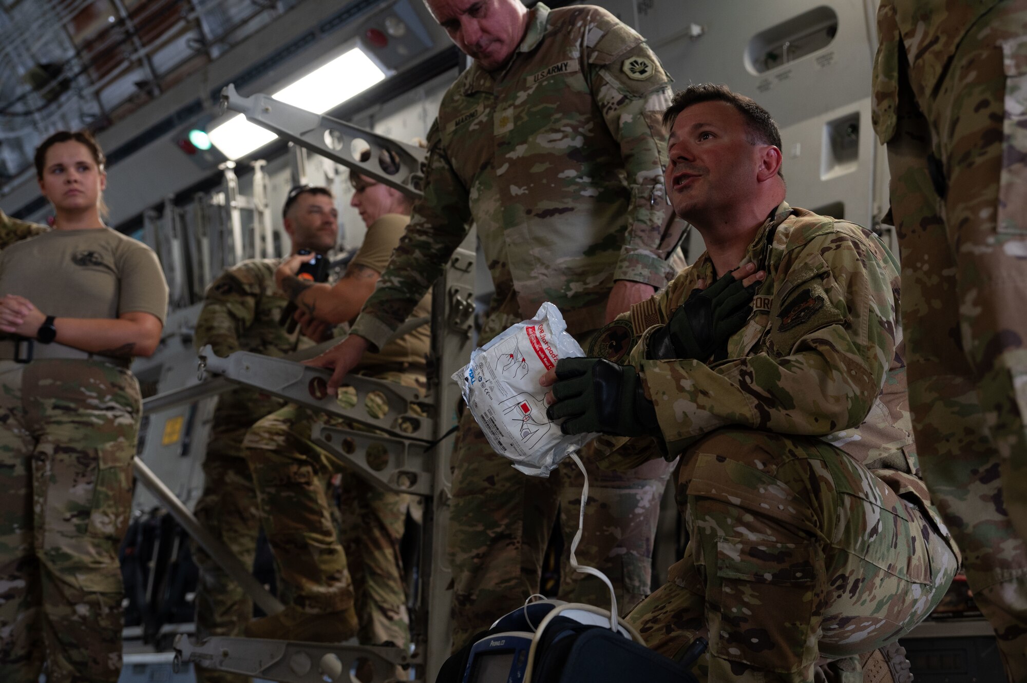 U.S. Air Force Maj. George Donavos, 379th Expeditionary Aeromedical Evacuation Squadron officer in charge, gives a brief during military working dog aeromedical evacuation training within the U.S. Central Command area of responsibility, July 22, 2025. Combining their knowledge, the Army Veterinary Corps and the 379th EAES provided hands-on training to 379th Expeditionary Medical Squadron and 379th Expeditionary Security Forces Squadron personnel to improve in-flight and ground care for MWDs. (U.S. Air Force photo by Senior Airman Dieondiere Jefferies)