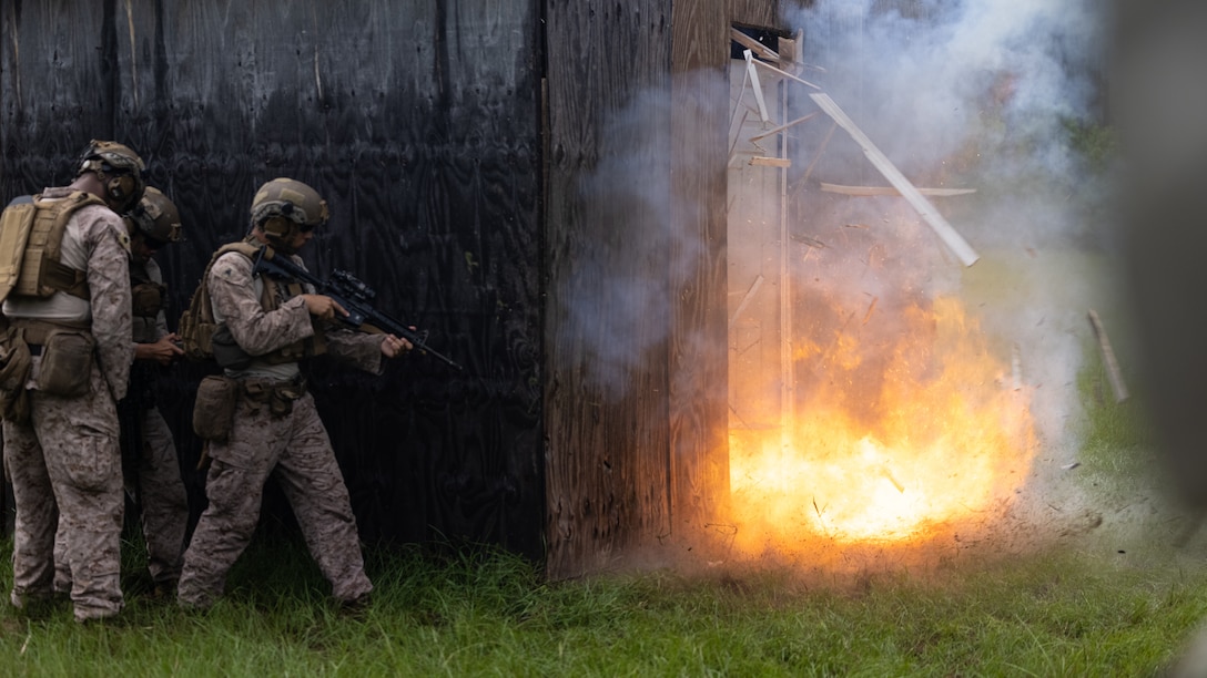 U.S. Marines with 2d Combat Engineer Battalion, 2d Marine Division detonate a linear detonation cord breaching charge during an urban breaching range for U.S. Naval Academy midshipmen at Marine Corps Base Camp Lejeune, North Carolina, July 31, 2025. While training with 2d CEB, the midshipmen observed how combat engineers build and employ explosive breaching charges in urban environments. (U.S. Marine Corps photo by Lance Cpl. Brian Bolin Jr.)