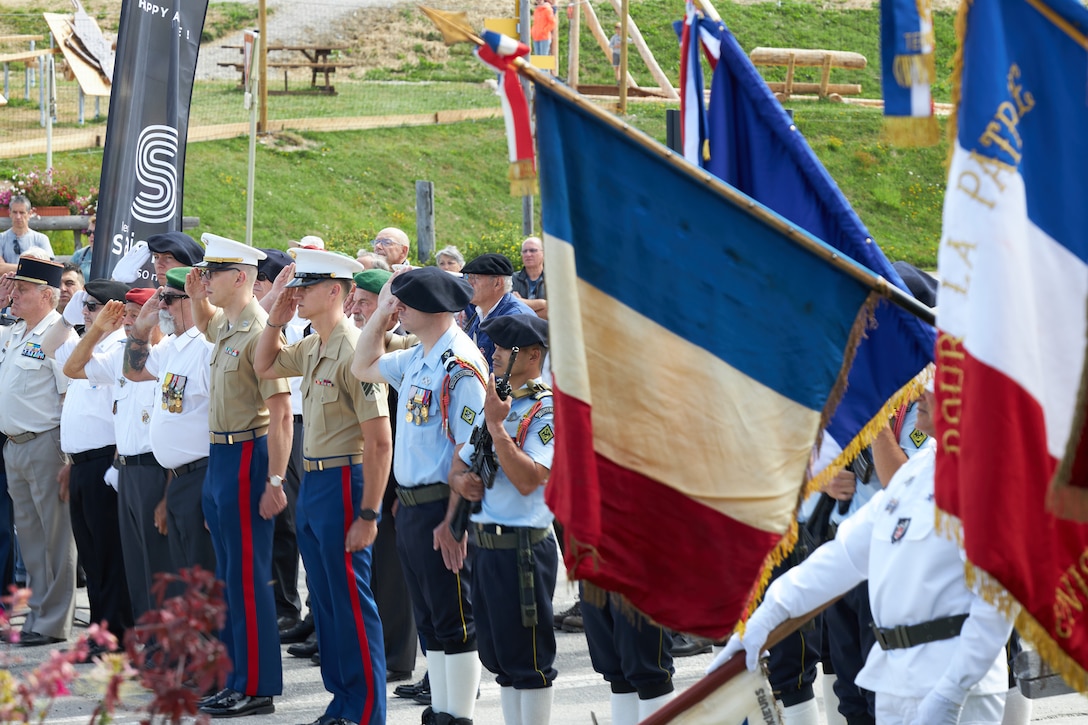 U.S. Marines and French Soldiers, Legionnaires and flag bearers salute during the Union II 81st Commemoration Anniversary ceremony in Les Saisies, France, Aug. 1, 2025. Union II was a WWII operation that involved the aerial insertion of six Marines, an Army Air Corps captain, and a French resistance fighter into the German-controlled French Alps in August of 1944. Their mission was to arm and train the French Resistance to aid in the fight to liberate Europe. When they found themselves surrounded by German forces in the village of Centron, the Marines surrendered in order to save the village from retaliation. Their sacrifice is remembered to this day. (U.S. Marine Corps photo by Sgt. Kedrick Schumacher
