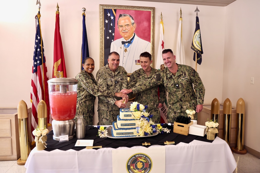 TWENTYNINE PALMS, Calif. — Rear Adm. Matthew Case (center-left), Chief of the Navy Medical Service Corps, visits Navy Medicine Readiness and Training Command Twentynine Palms, July 30, 2025. The two-star admiral’s visit centered on celebrating the MSC’s’ legacy while addressing the challenges and responsibilities ahead for both Navy Medicine and the Defense Health Agency as a whole. During a traditional cake-cutting ceremony, Rear Adm. Case, the most senior MSC officer present, joined Lt. j.g. David Naiman (center-right), the youngest MSC officer, along with commanding officer Capt. Janiese Cleckley (left) and the director for administration Cmdr. William “Bill” Lawson (right), to cut the ceremonial birthday cake together — marking 78 years of the Medical Service Corps. The visit also included facility tours, leadership engagements, and an all-hands MSC officers call highlighting the Corps’ ongoing commitment to medical readiness and support of the warfighter (U.S. Navy photo by Christopher Jones, NMRTC/NH public affairs officer).