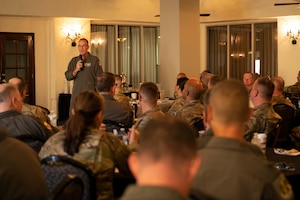 man speaking at a conference to seated crowd