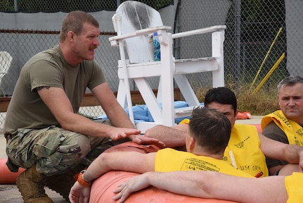 U.S. Air Force Master Sgt. Steven Harper, aircrew flight equipment technician with the 117th Operation Support Squadron, assesses the survival procedure knowledge of aircrew members inside a 20-person rescue raft during water survival training in Trussville, Alabama, August 2, 2025.