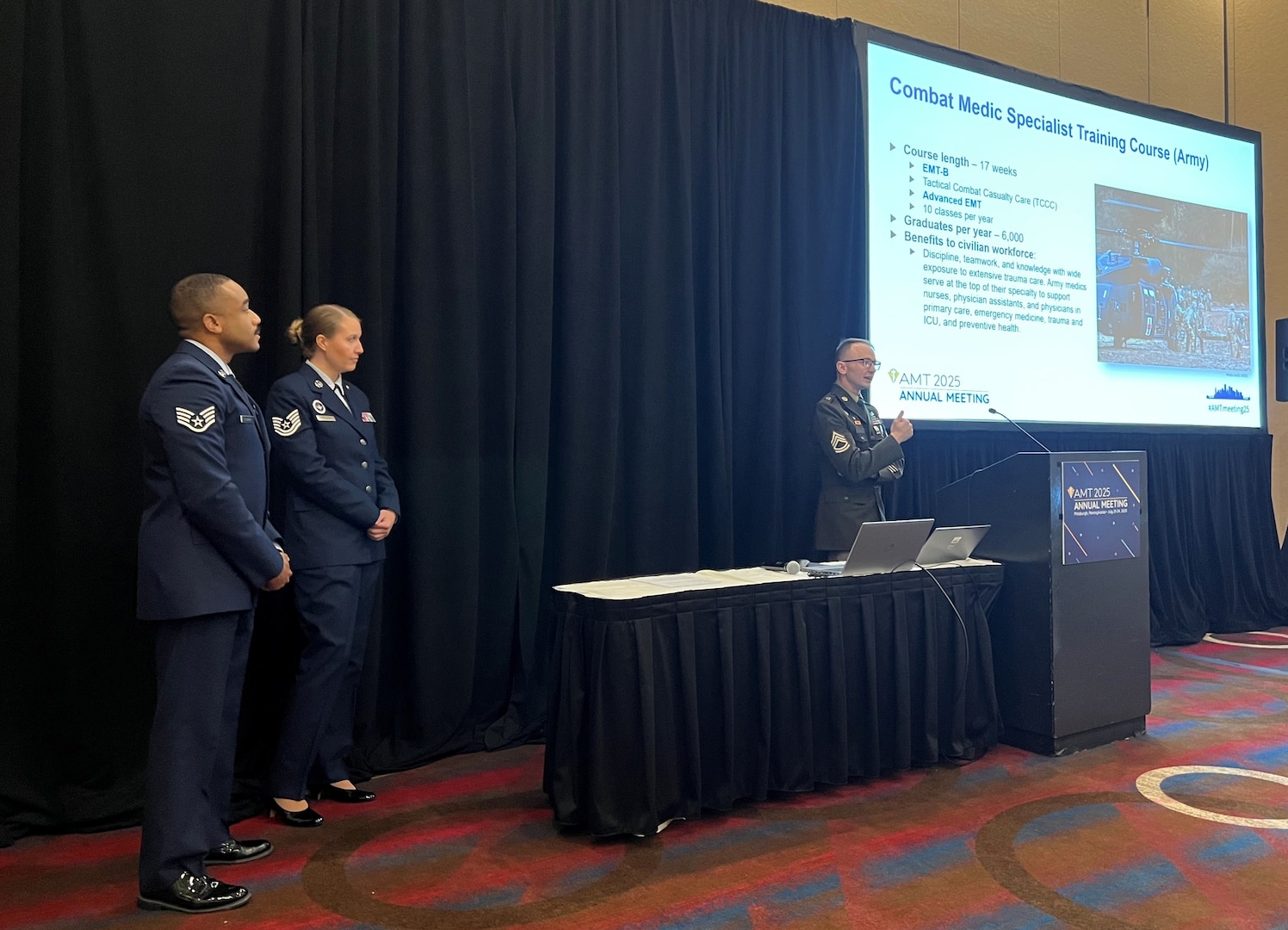 Army Sgt. 1st Class Devin Bigelow, an instructor for the Combat Medic Specialist Training Course (CMSTC) at the Medical Education and Training Campus on Joint Base San Antonio-Fort Sam Houston, Texas, delivers a presentation about the CMSTC at the American Medical Technologists Annual Meeting in Pittsburgh, Pa. July 23 while fellow METC instructors, Air Force Tech. Sgt. Jessica McCleary and Air Force Staff Sgt. Jheryl Stuckey, look on.