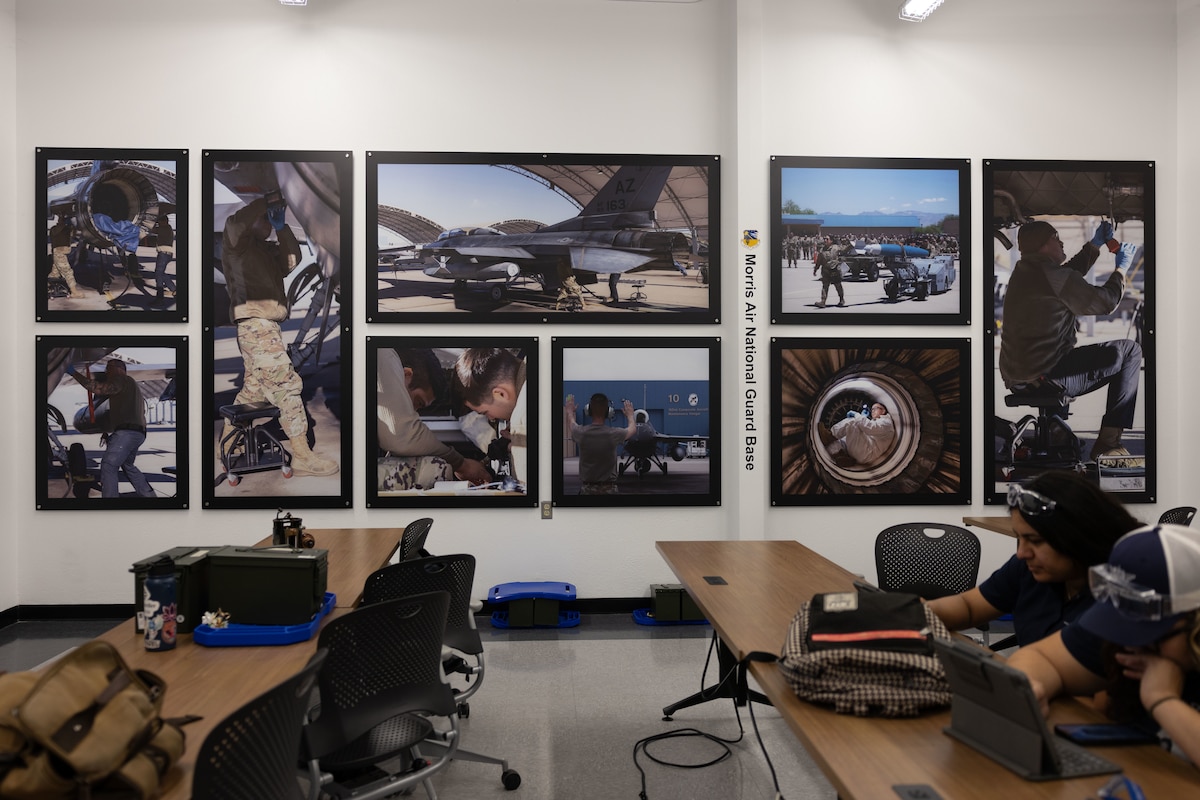 Operational imagery from 162nd Wing aviation maintenance missions displayed on the walls of the Air National Guard classroom at Pima Community College's Aviation Program in Tucson, Ariz., July 29, 2025. The displays provide students exposure to Air National Guard capabilities and career fields, reinforcing how civilian aviation education translates to military mission support. (U.S. Air National Guard photo by Staff Sgt. Guadalupe Beltran)