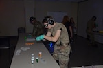 Army Staff Sgt. Brandi Seif, METC operations staff, attempts to perform an individual task under impaired conditions while participating in the Dementia Experience. The Dementia Experience is an innovative, immersive dementia simulation that allows participants to personally experience the daily challenges that cognitively impaired people face.
