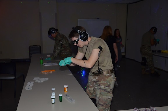 Army Staff Sgt. Brandi Seif, METC operations staff, attempts to perform an individual task under impaired conditions while participating in the Dementia Experience. The Dementia Experience is an innovative, immersive dementia simulation that allows participants to personally experience the daily challenges that cognitively impaired people face.