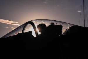 silhouette profile of fighter pilot inside fighter jet