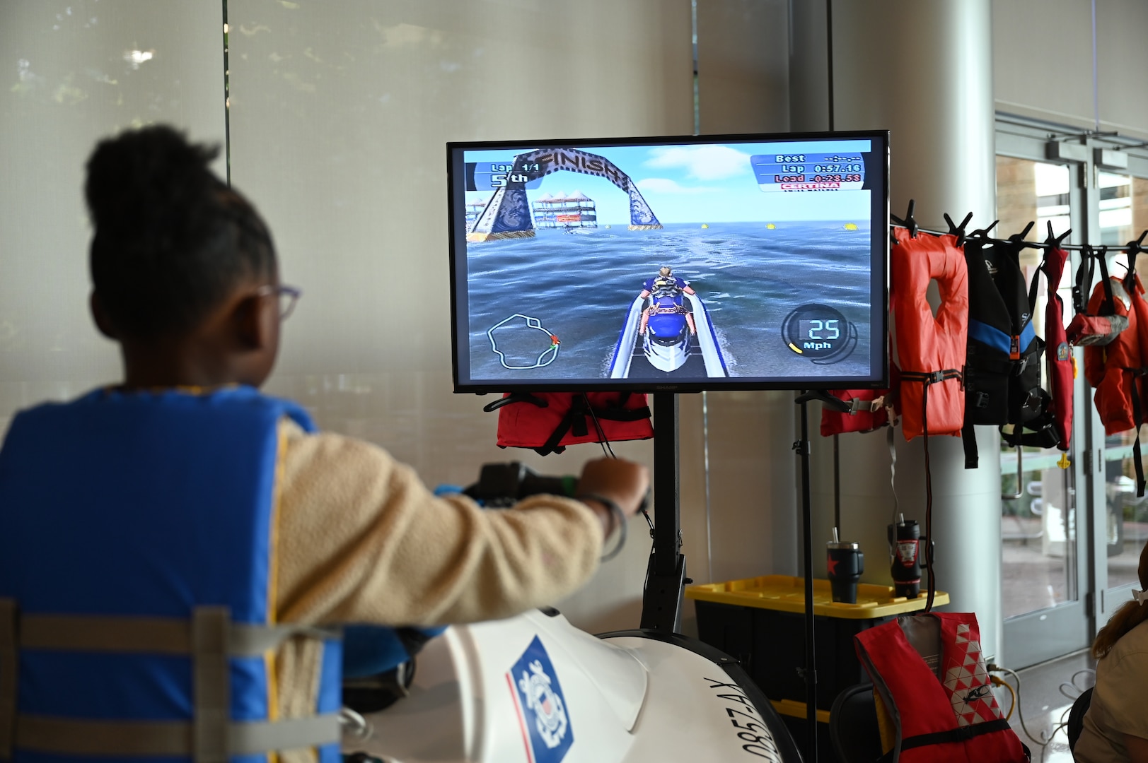 A young participant learns about water safety while riding a simulated jet ski at one of the educational booths during Kidz Fest at Carl. R. Darnall Army Medical Center, Aug. 2. The interactive station used video game-style learning to engage children in safety awareness.
