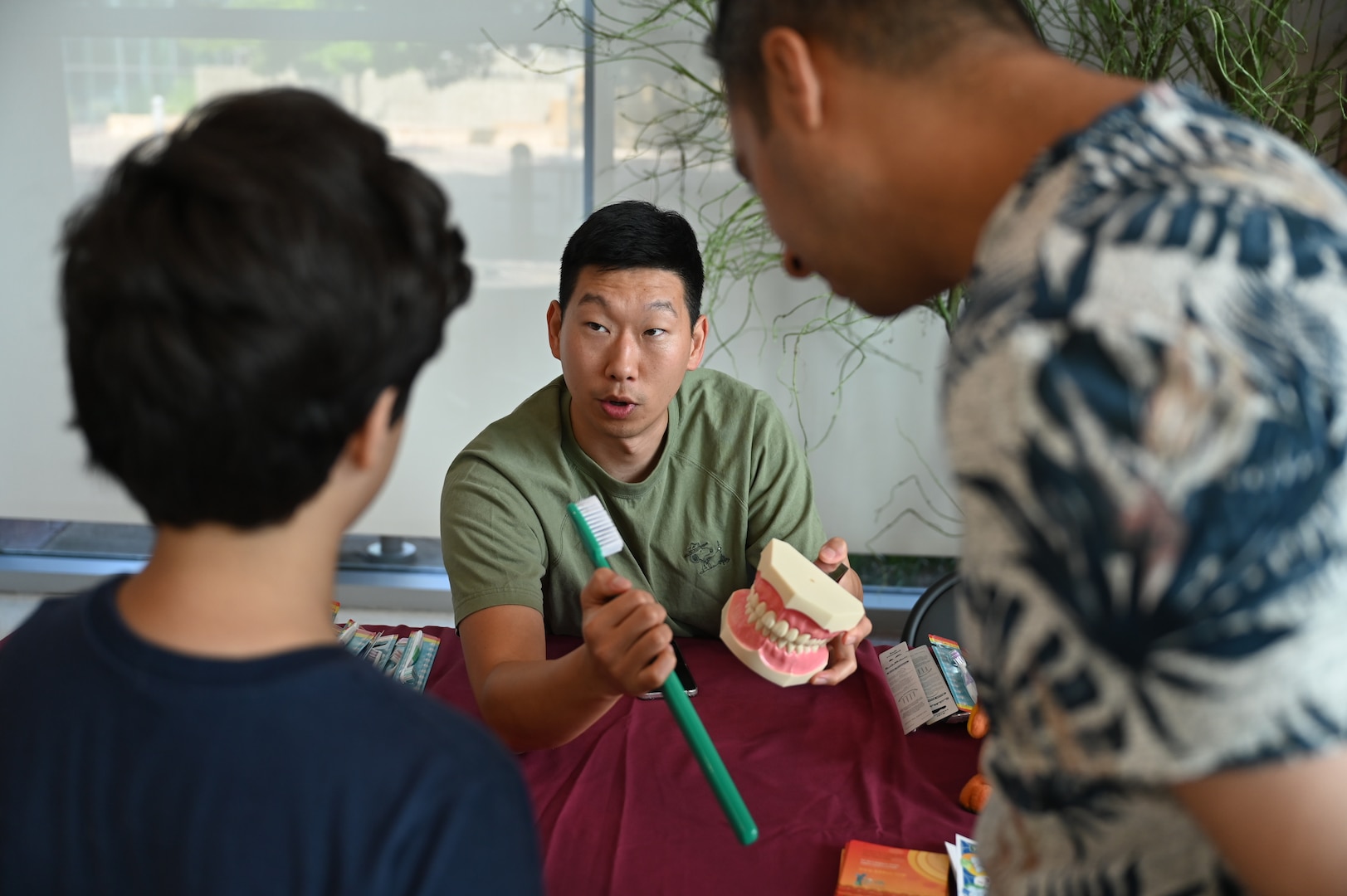 Dr. Daemin Jeon, Perkins Dental Clinic, uses a giant toothbrush and model teeth to teach a child about proper brushing habits during Kidz Fest at CRDAMC, Aug. 2. The dental education booth emphasized the importance of early oral hygiene.