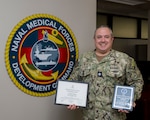 Cmdr. Thomas Sather, director of the Naval Medical Forces Development Command’s Tactical Combat Casualty Care program, displays his recent civilian awards at Joint Base San Antonio-Fort Sam Houston, Texas, Aug. 1, 2025. Sather was presented the American Red Cross Chairpersons’ Award for his significant contributions to the Red Cross Scientific Advisory Council, and recognized the Aerospace Medical Association with the Aerospace Physiology Society’s Fred A. Hitchcock Award for his outstanding performance as a senior aerospace physiologist. (U.S. Navy photo by Malcolm McClendon)