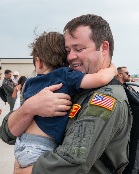 An Airman holds a small child into a hug.
