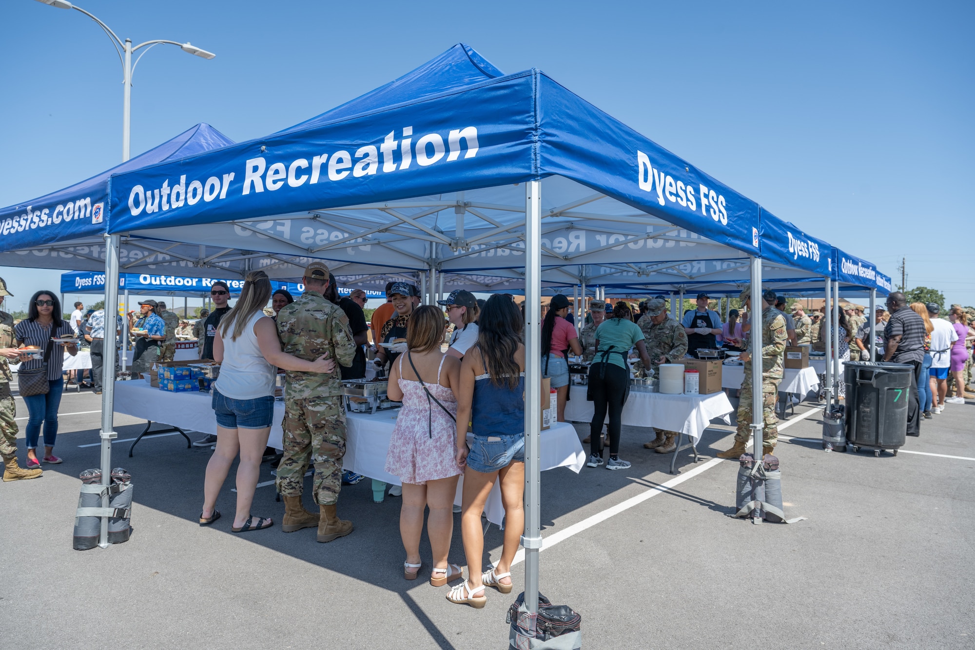 Volunteers serve food to Airmen and their families during the “Breaking Bread with Heroes” event at Dyess Air Force Base, Texas, July 31, 2025. The event, hosted by the Robert Irvine Foundation, aimed to offer a meaningful show of support to service members across the installation. (U.S. Air Force photo by Airman Caleb Schellenberg)