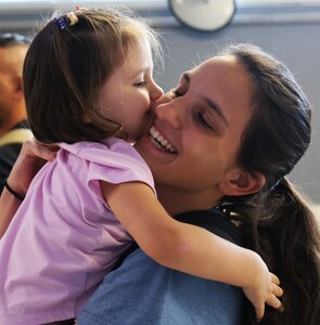 Staff Sgt. Summer Sparacino hugs her 2-year-old daughter, Francesca, as Sparacino returns from deployment. The Illinois Army National Guard's 634th Brigade Support Battalion Forward Logistics Element returned home on Saturday, Aug. 2, after supporting U.S. Special Operations Command Africa for approximately six months.