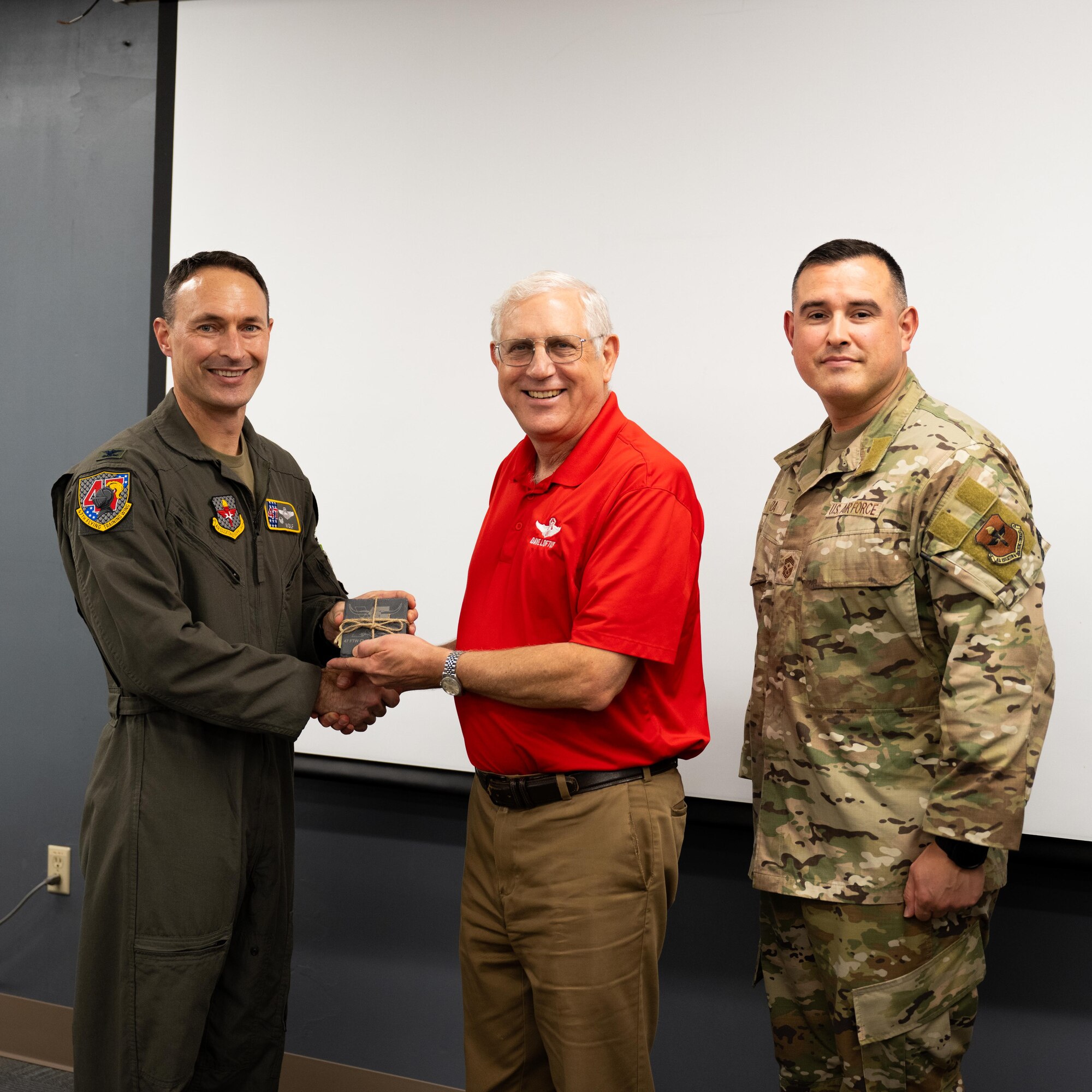 U.S. Air Force Col. Tyler Ellison, 47th Flying Training Wing commander, and Chief Master Sgt. Erik Garza, 47th FTW command chief, present a second quarter award at Laughlin Air Force Base, August 1, 2025. The quarterly awards ceremony honored Airmen and civilians who demonstrated exceptional performance, leadership, and mission impact across the wing. (U.S. Air Force photo by Airman 1st Class Harrison Sullivan)