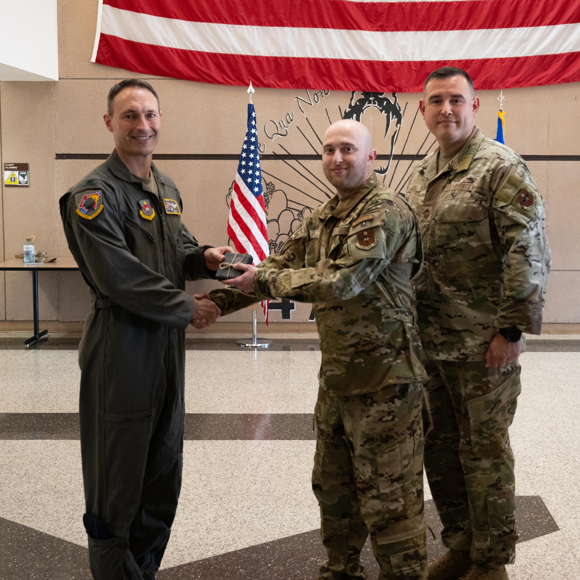 U.S. Air Force Col. Tyler Ellison, 47th Flying Training Wing commander, and Chief Master Sgt. Erik Garza, 47th FTW command chief, present a second quarter award at Laughlin Air Force Base, August 1, 2025. The quarterly awards ceremony honored Airmen and civilians who demonstrated exceptional performance, leadership, and mission impact across the wing. (U.S. Air Force photo by Airman 1st Class Harrison Sullivan)