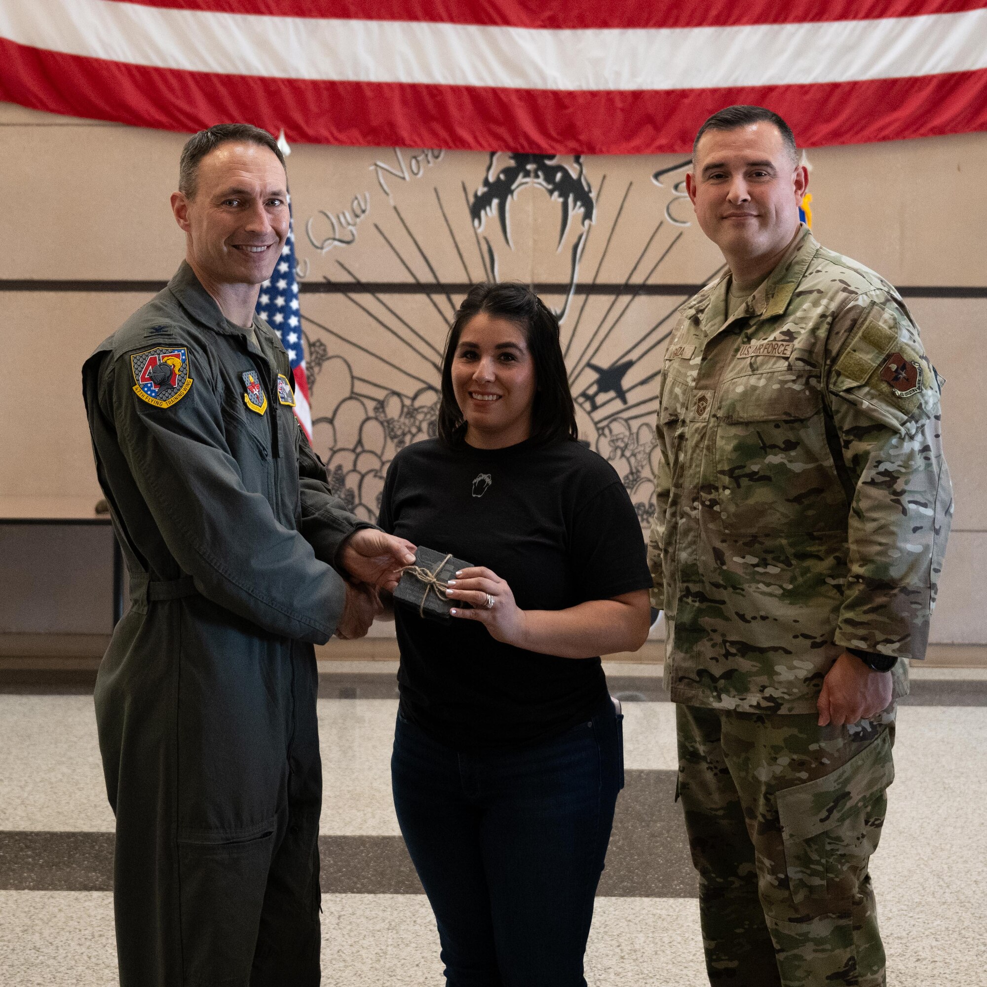 U.S. Air Force Col. Tyler Ellison, 47th Flying Training Wing commander, and Chief Master Sgt. Erik Garza, 47th FTW command chief, present a second quarter award at Laughlin Air Force Base, August 1, 2025. The quarterly awards ceremony honored Airmen and civilians who demonstrated exceptional performance, leadership, and mission impact across the wing. (U.S. Air Force photo by Airman 1st Class Harrison Sullivan)