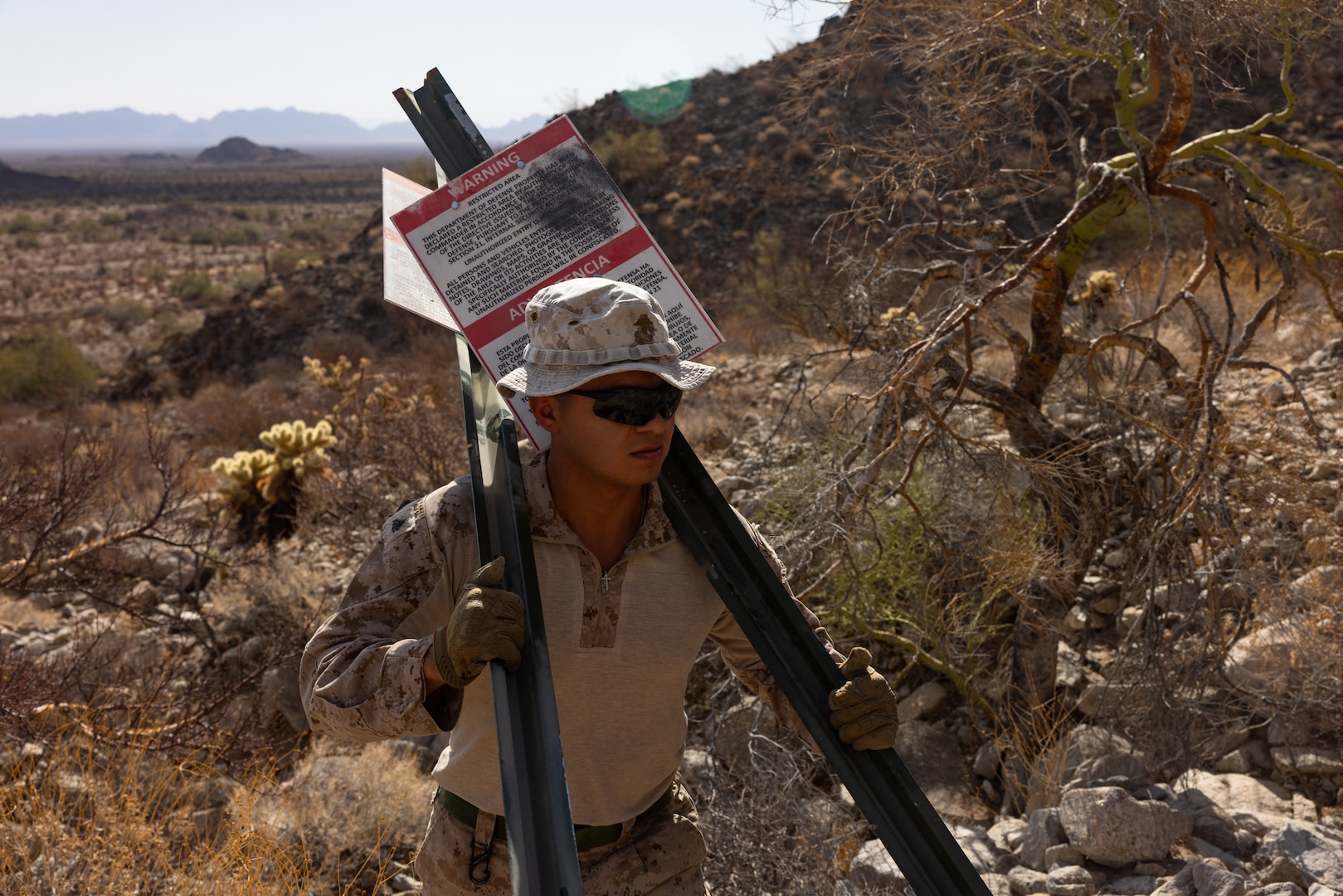 U.S. Marine Corps Cpl. William Cordero with Combat Logistics Battalion 15 (CLB-15), Combat Logistics Regiment 17, 1st Marine Logistics Group, assigned to Joint Task Force-Southern Border, hikes to pre-identified grid points to emplace National Defense Area signage in Yuma, Ariz., July 31, 2025. JTF-SB executes full-scale, agile, and all-domain operations in support of U.S. Customs and Border Protection to protect the territorial integrity of the United States and achieve 100% operational control of the southern border. (U.S. Marine Corps photo by Sgt. Mary Torres)