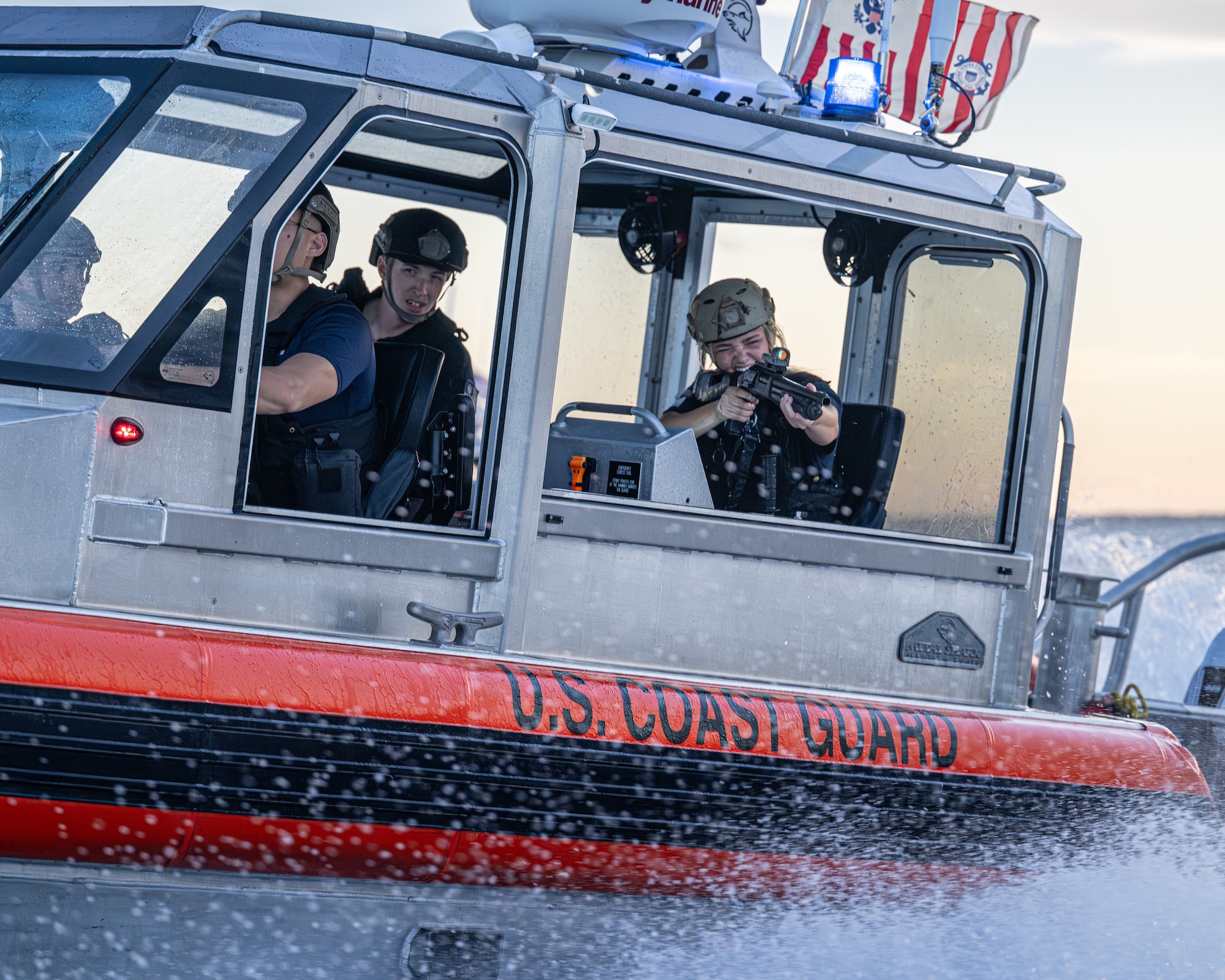 A U.S. Coast Guard member with MSST Miami aims a training weapon from a Response Boat–Medium during a Non-Compliant Vessel Pursuit exercise in Biscayne Bay, June 16, 2025.