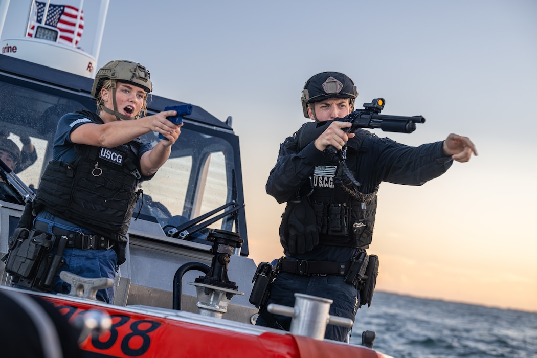 Two U.S. Coast Guard members with MSST Miami aim training weapons from a Response Boat–Medium during a Non-Compliant Vessel Pursuit training event in Biscayne Bay, Florida, June 16, 2025.