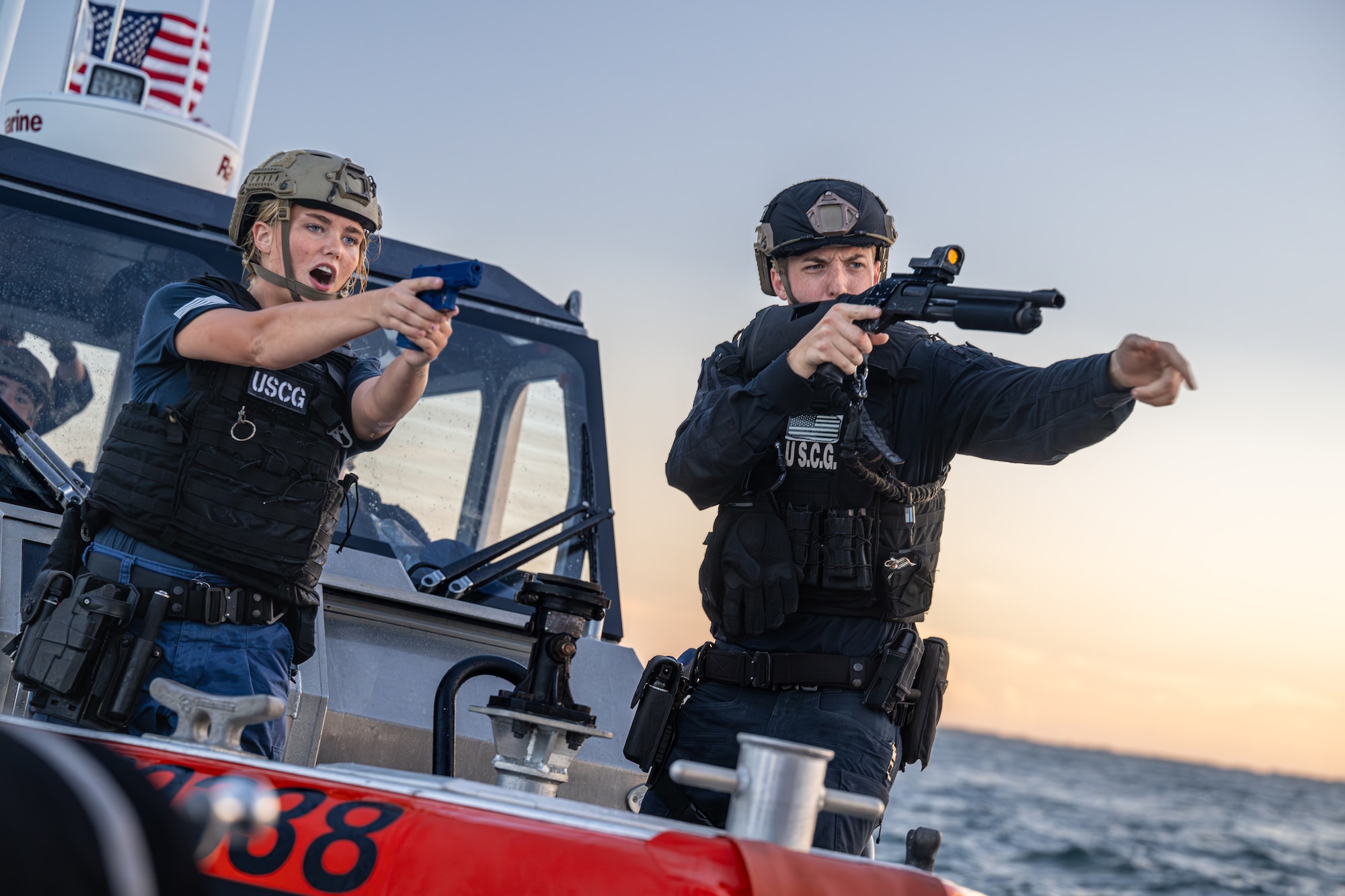 Two U.S. Coast Guard members with MSST Miami aim training weapons from a Response Boat–Medium during a Non-Compliant Vessel Pursuit training event in Biscayne Bay, Florida, June 16, 2025.