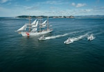 U.S. Coast Guard Barque Eagle (WIX-327) and three 47-foot Motor Life Boats sail past the Cape Disappointment Lighthouse, at the mouth of the Columbia River, June 16, 2025. Eagle departed Astoria, Oregon after a four-day port call. (U.S. Coast Guard photo by Petty Officer 3rd Class Daylan M. Garlic-Jackson)