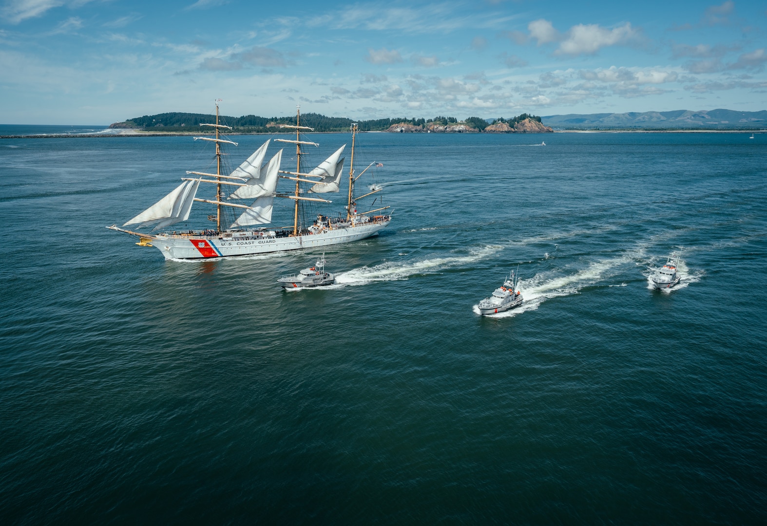 U.S. Coast Guard Barque Eagle (WIX-327) and three 47-foot Motor Life Boats sail past the Cape Disappointment Lighthouse, at the mouth of the Columbia River, June 16, 2025. Eagle departed Astoria, Oregon after a four-day port call. (U.S. Coast Guard photo by Petty Officer 3rd Class Daylan M. Garlic-Jackson)