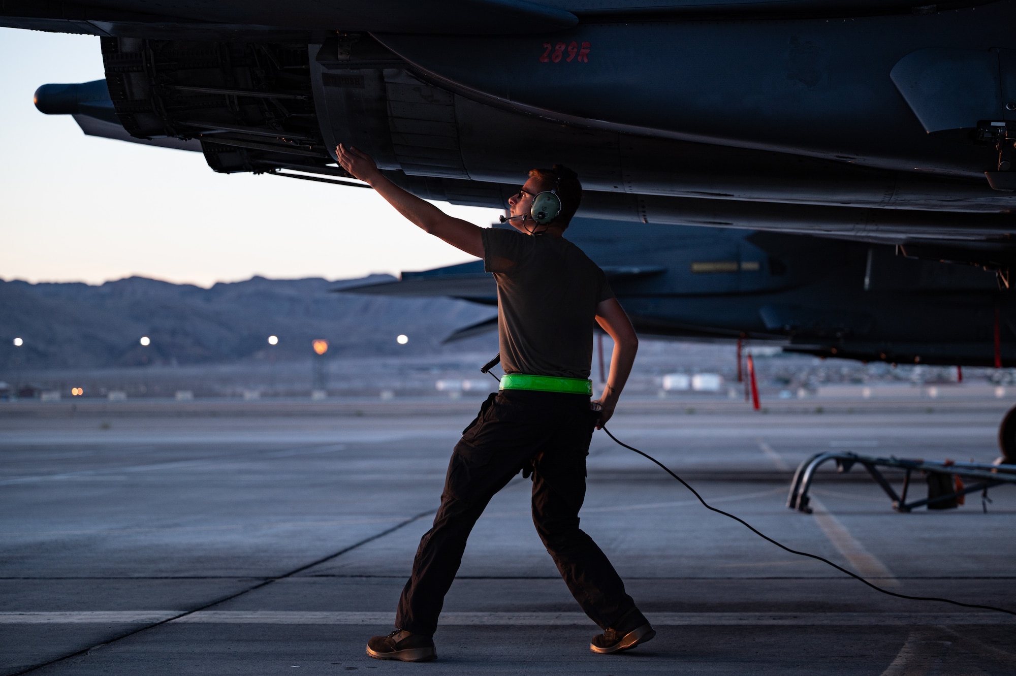 Airmen walks under plane.