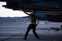 Airmen walks under plane.