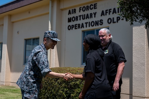 A Japan Air Self-Defense Force commander shakes hands with a civilian mortuary affairs personnel.