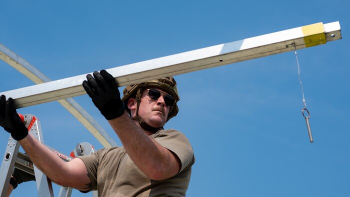 U.S. Air Force Master Sgt. Nick Porter, 60th Civil Engineer Squadron project management section chief, assigned to the 22nd Air Task Force (ATF) places a tent frame section as part of the advanced echelon (ADVON) team in preparation for Exercise Northern Strike 25-2 (NS 25-2) at Battle Creek Air National Guard Base, Michigan, Aug. 2, 2025.