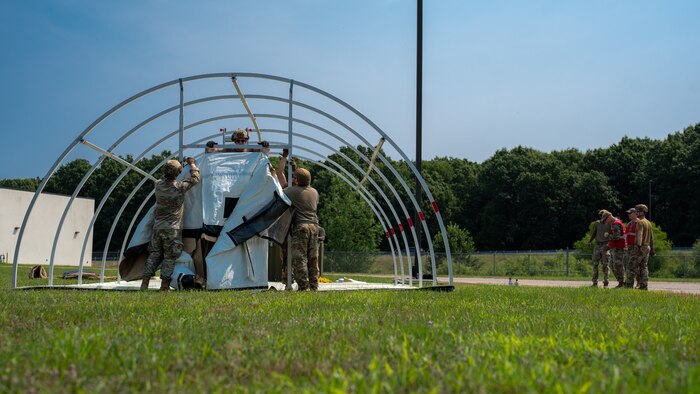 U.S. Airmen from various installations assigned to the 22nd Air Task Force (ATF) position a tent’s outer shell as part of the advanced echelon (ADVON) team while Wing Inspection Team members observe in preparation for Exercise Northern Strike 25-2 (NS 25-2) at Battle Creek Air National Guard Base, Michigan, Aug. 2, 2025.