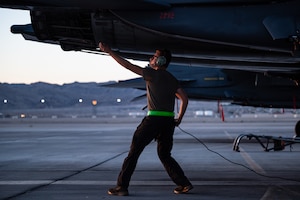 Airmen walks under plane.